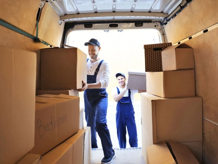 Delivery men unloading moving boxes from car — Removalist in Brisbane, QLD