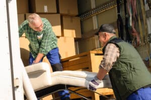 Two Men Putting Furnitures Inside a Truck